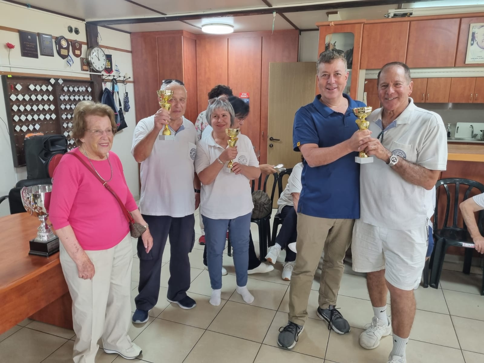 ישראל גל, ראש העיר קריית אונו וטובה אחידוב, מעניקים גביעים לשחקני כדורת דשא קרית אונו, בתום טורניר אחידוב השנתי. צילום: מועדון הכדורת