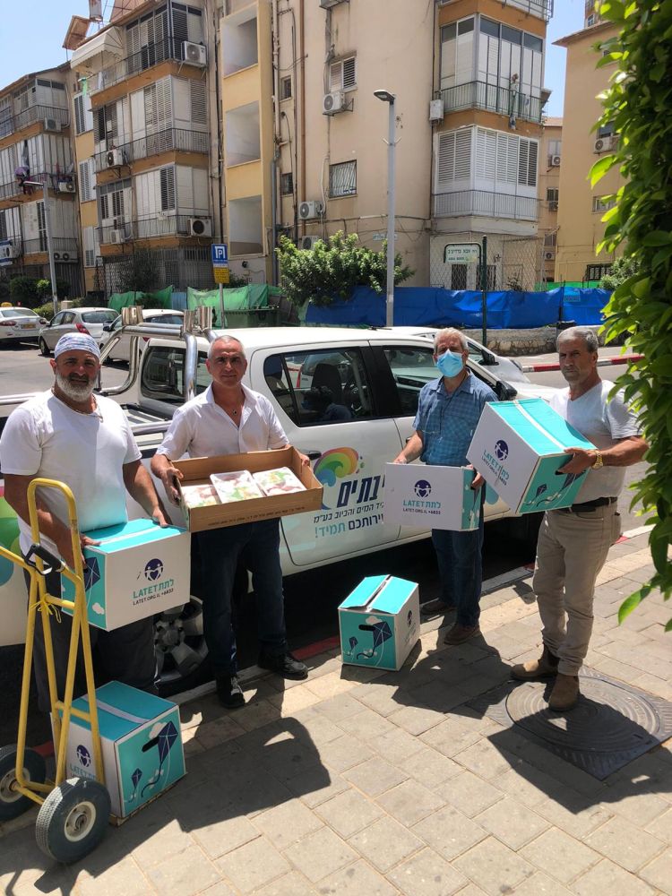 איציק דריקס, יו"ר דירקטוריון מי בת-ים והמנכ"ל טל טורן בעת חלוקת החבילות בשיתוף עם עמותת אוהבים וארגון לתת- צילום: תאגיד מי בת ים