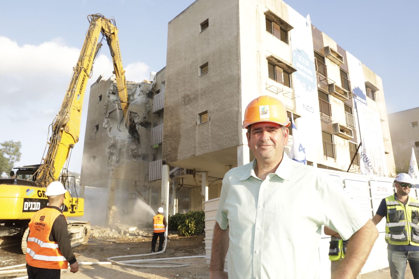 תמונה: יוסי ברודני על רקע הריסת המבנים <br> צילום: יעל צור